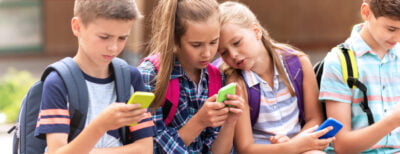 Fyra elever sitter med sina mobiltelefoner. Texten "Smartare än din telefon" står skrivet stort över bilden.
