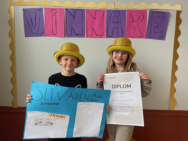 Daniel och Meja, vinnare av Innovate Challenge, har på sig guldhattar och håller i diplom.