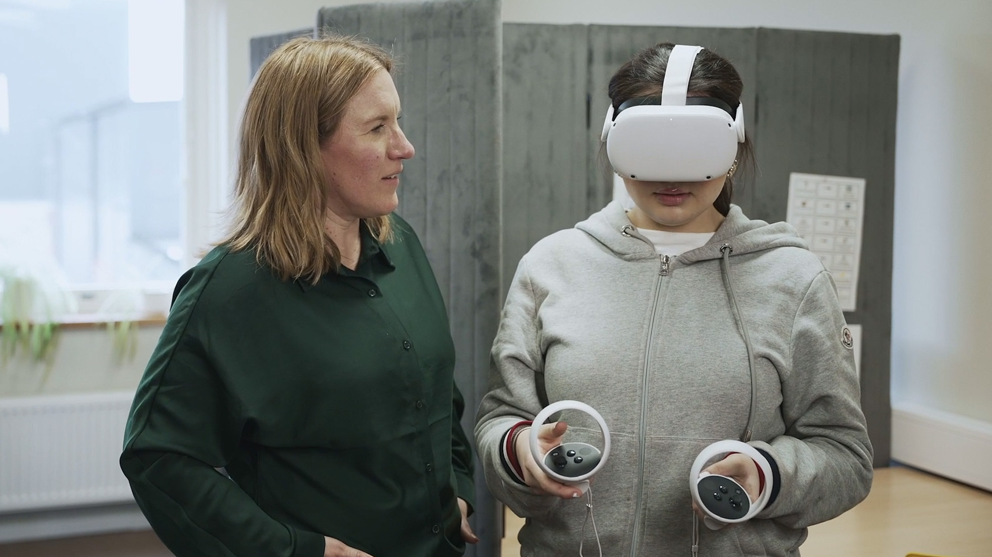 En elev utforskar VR-glasögon tillsammans med en lärare.