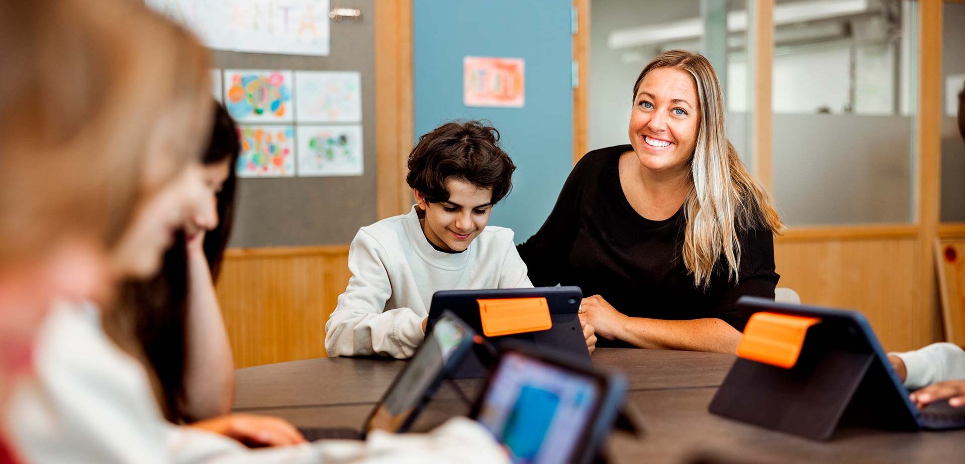 Elever och en lärare på Innovitaskolan jobbar med läsplattor.