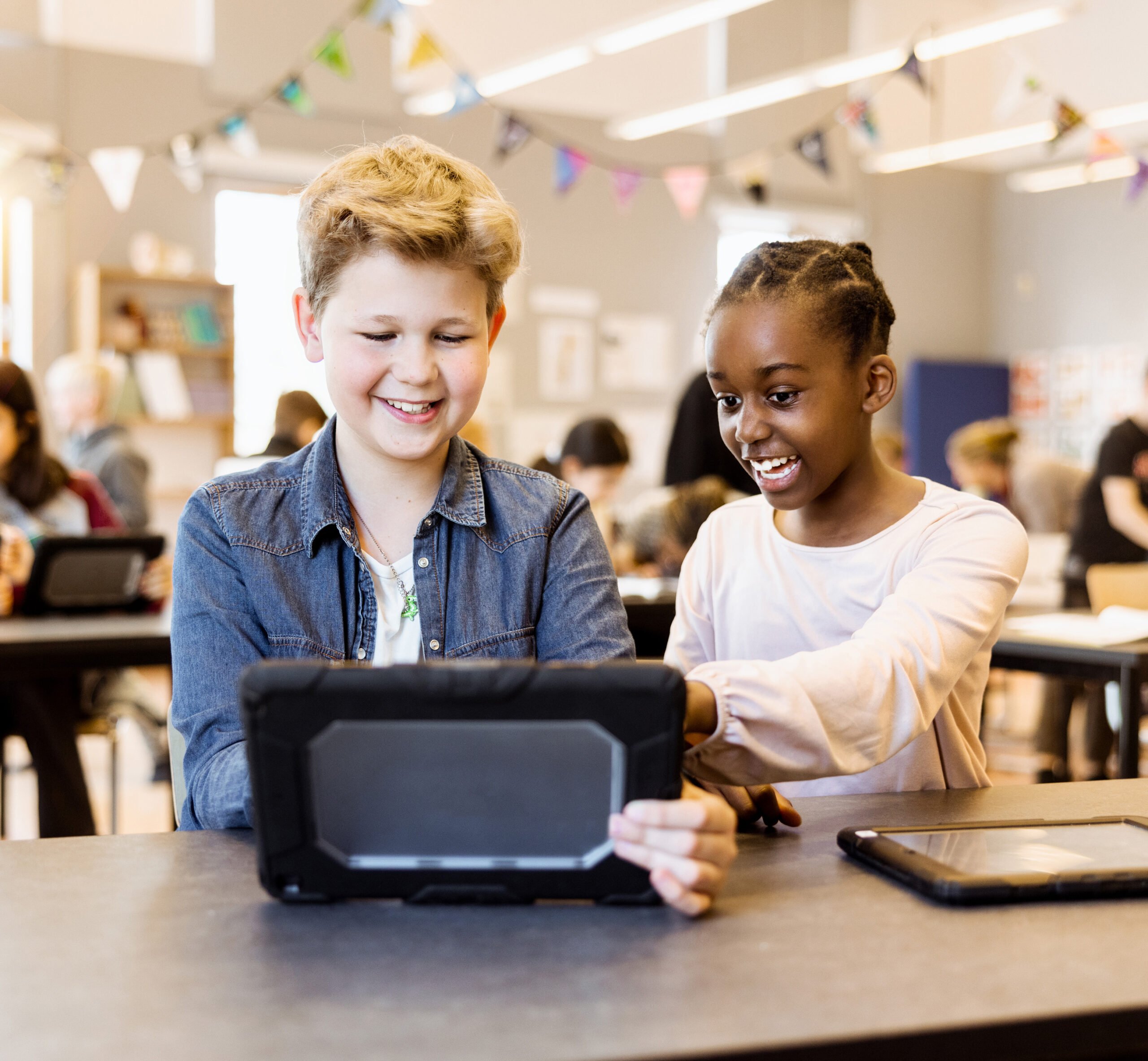 Två elever på Innovitaskolan jobbar med en iPad.