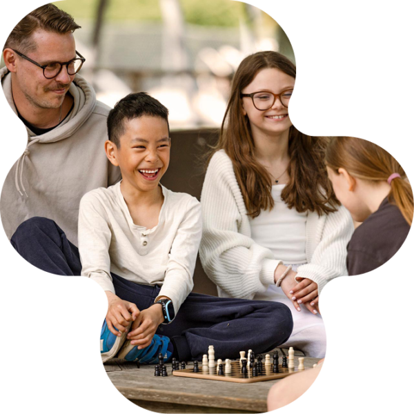 Elever spelar schack utomhus.