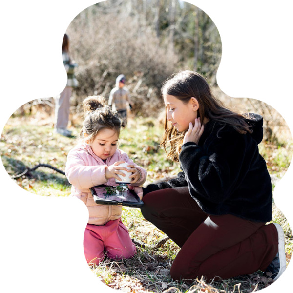 Barn och elev som leker i skogen.