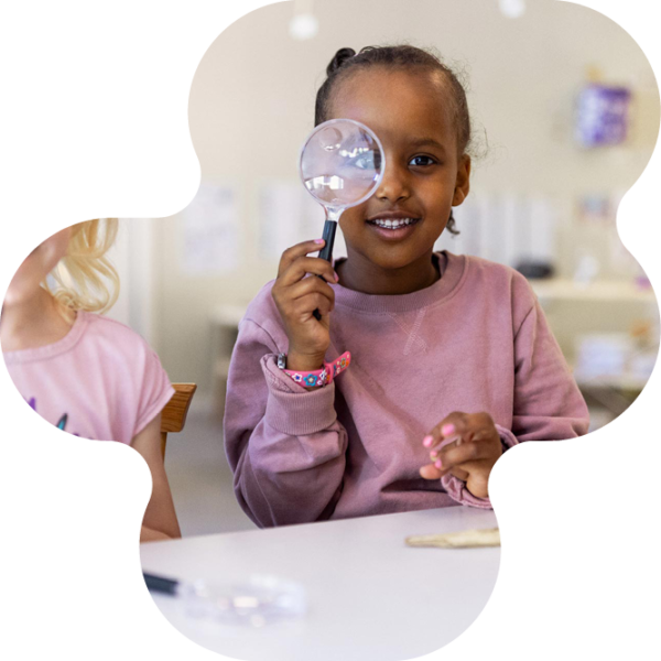 Barn som tittar i förstoringsglas.