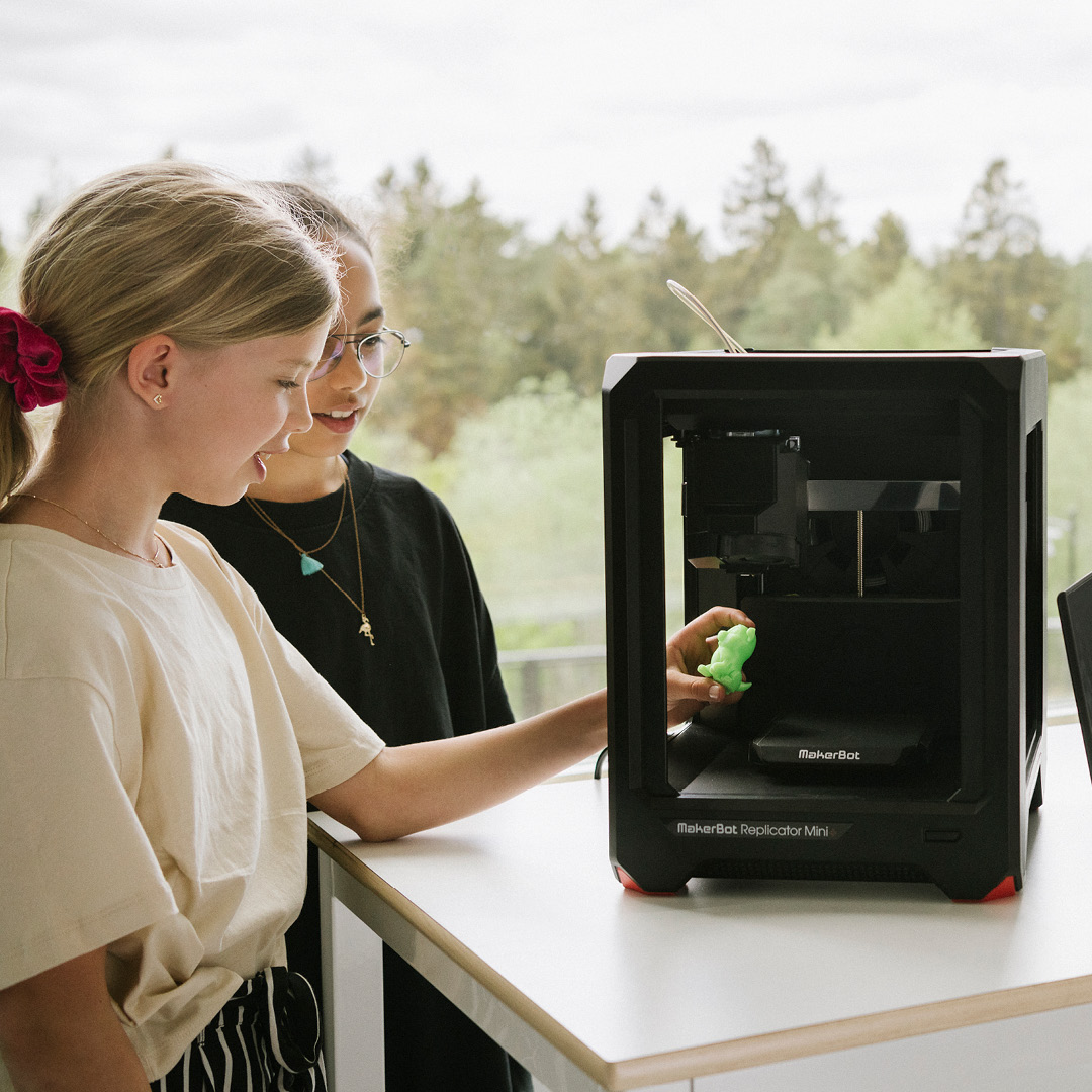 Två mellanstadieelever som arbetar med en 3D-printer på Innovitaskolan