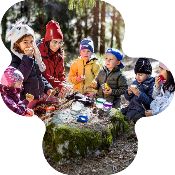 Barn och lärare som fikar i skogen.