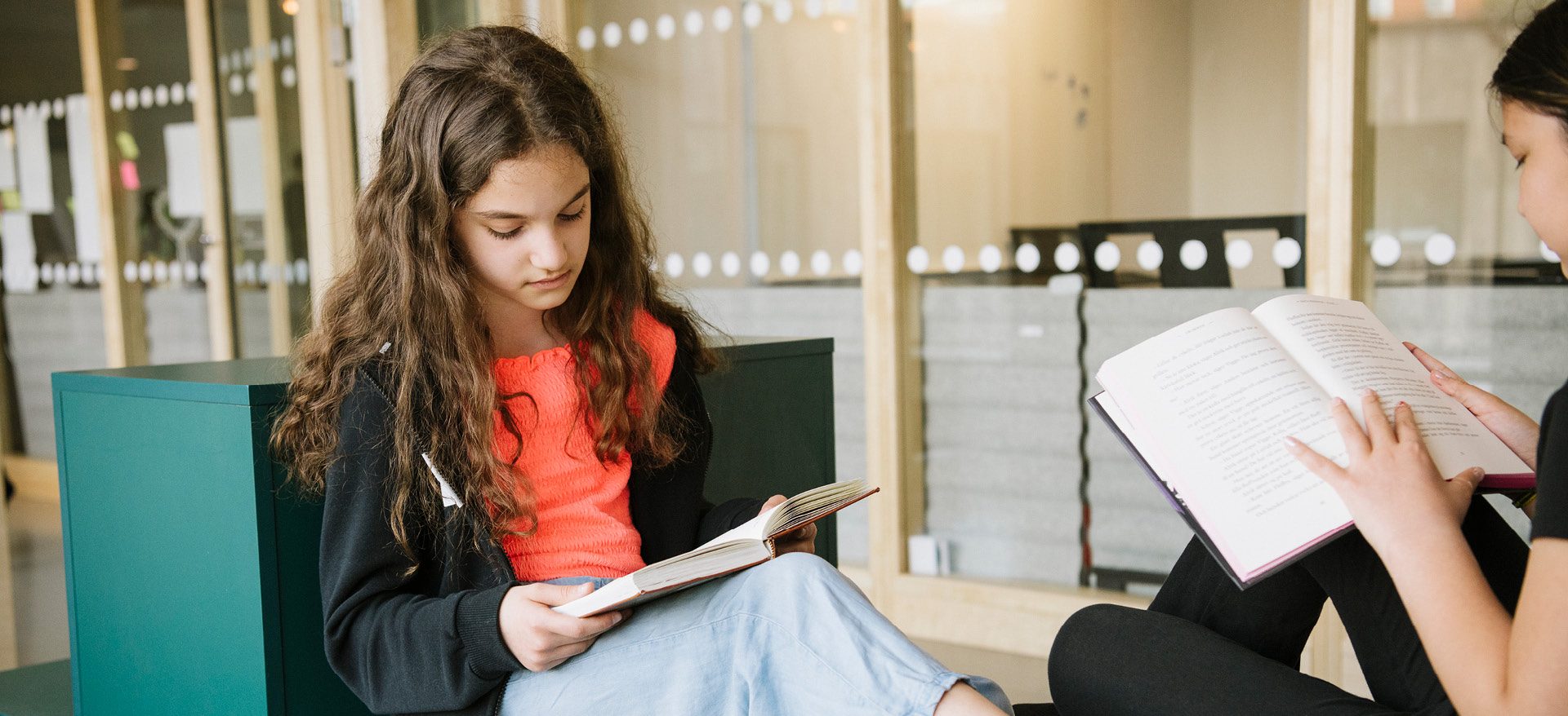Två elever i mellanstadiet som läser böcker i en skolmiljö