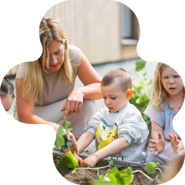 Pedagog planterar med förskolebarn.
