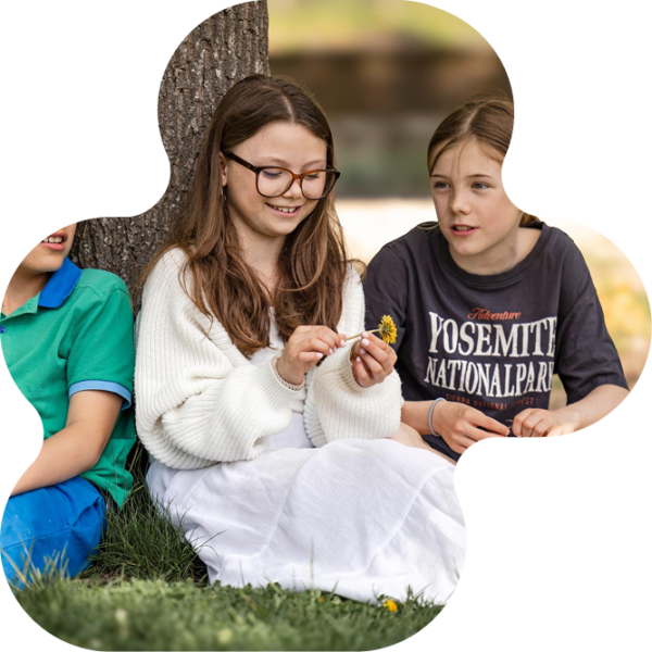 Elever som sitter under ett träd tillsammans.